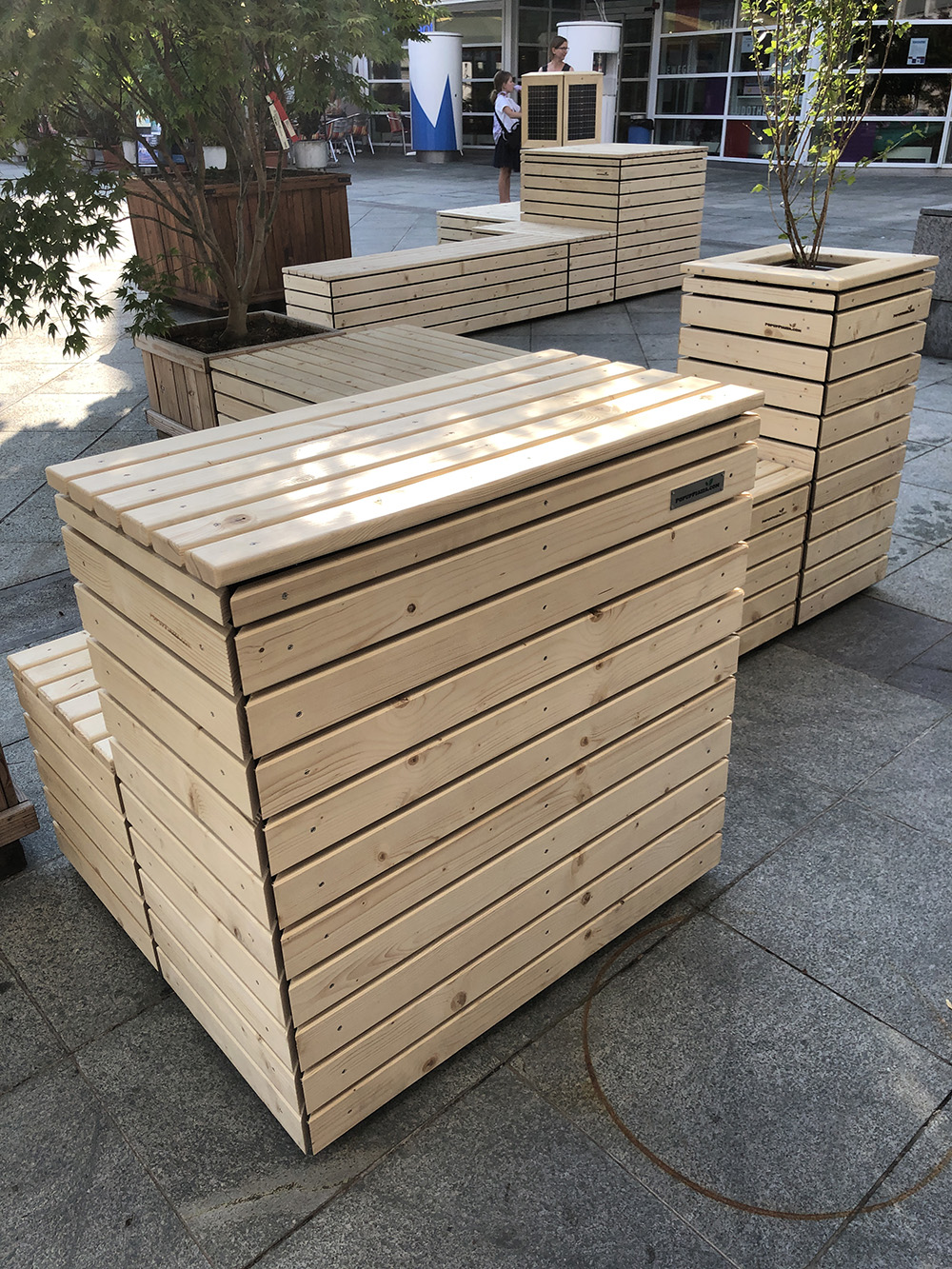 Die drei PopUp Piazza Inseln mit Holzelementen und Bäumen präsentieren sich gut auf dem Dorfplatz.